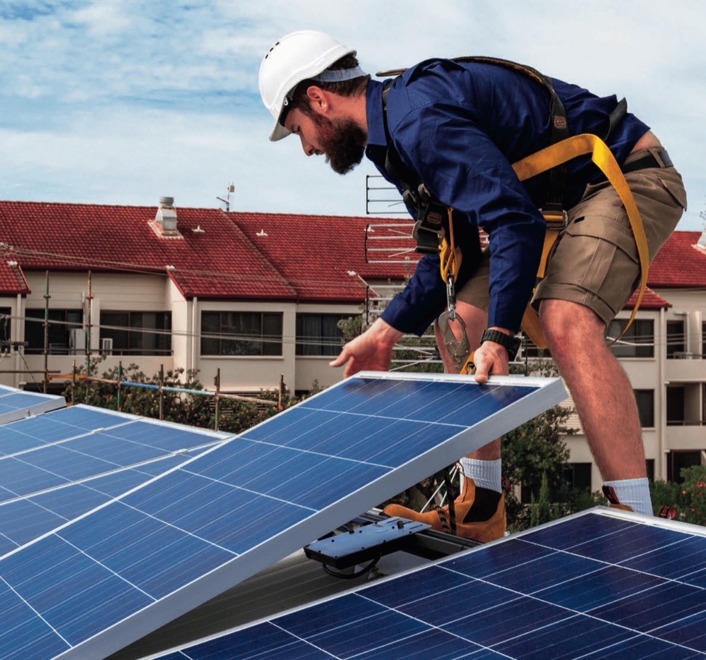 Monteur installiert eine Photovoltaikanlage auf einem Schrägdach